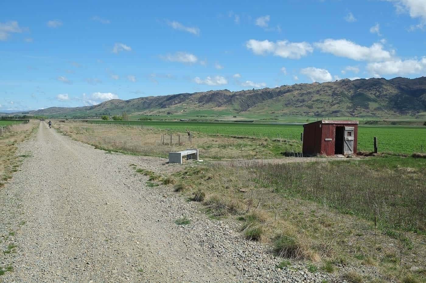 A rail trail crossing a broad open valley with distant mountains